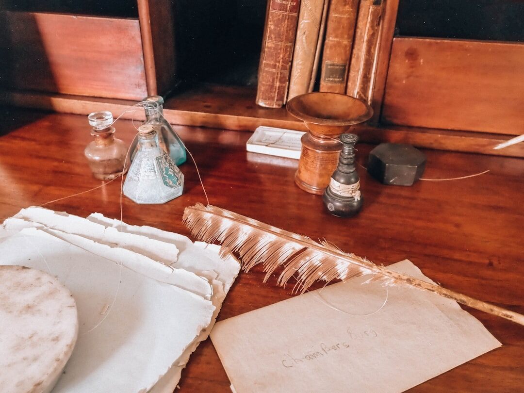 Vintage typewriter on a wooden desk with scattered papers and a cup of coffee